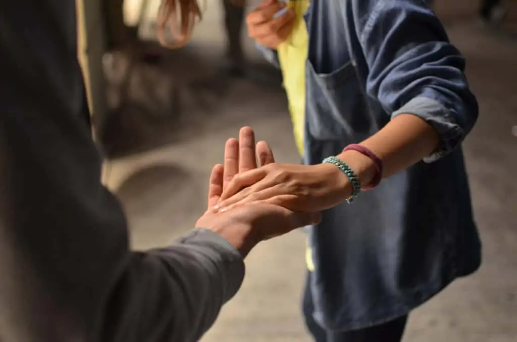 Hands touching, symbolising charity and support.